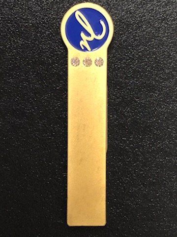 A gold bookmark with the letter l on it