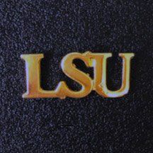 A close up of a gold lsu logo on a black surface.