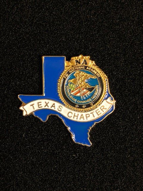 A blue texas chapter pin on a black background