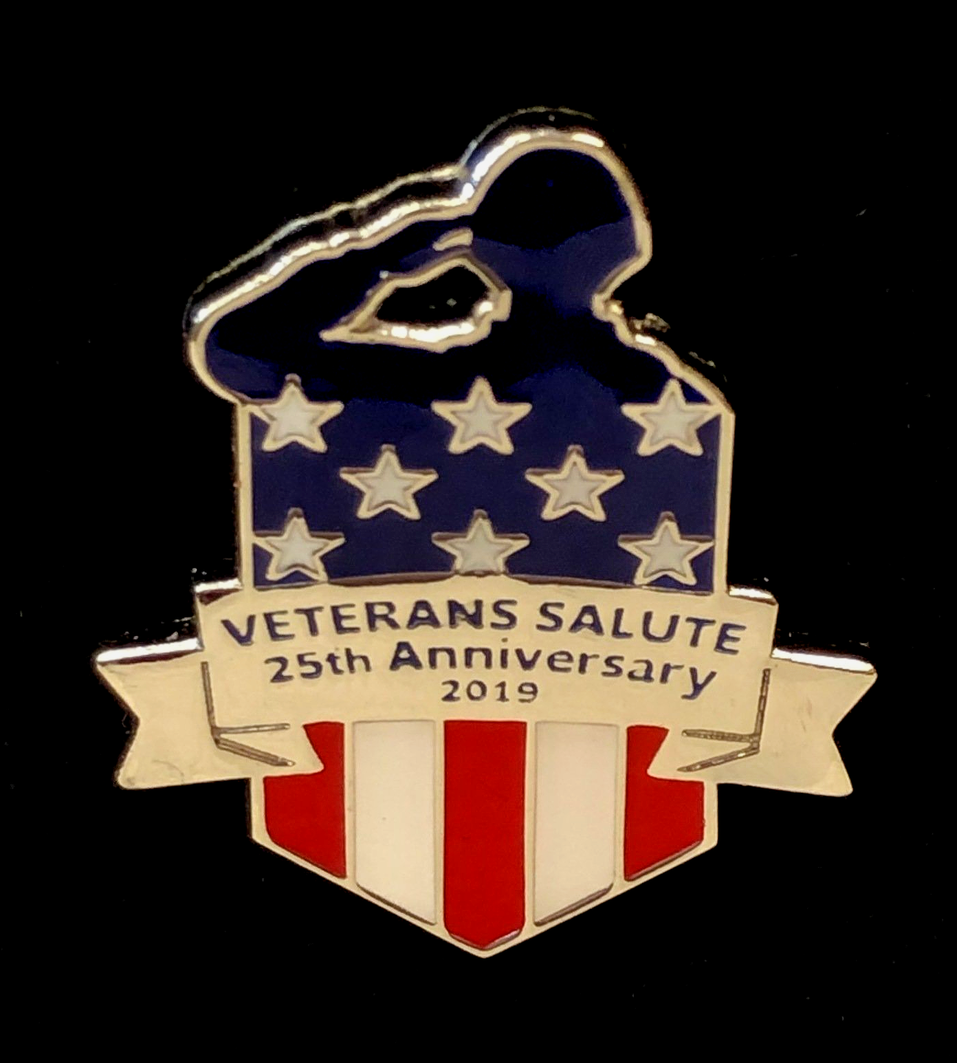 A pin that says veterans salute 25th anniversary 2019