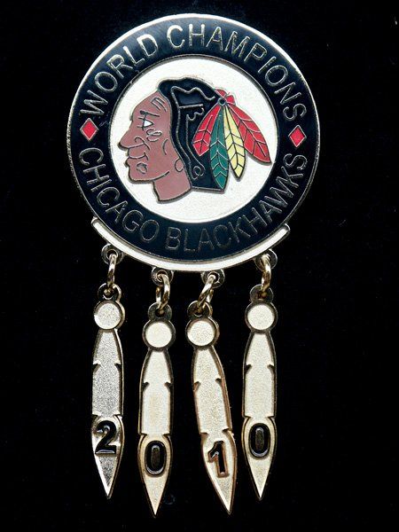 A chicago blackhawks world champions pin with feathers hanging from it