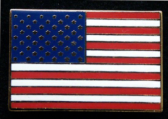 A red white and blue american flag pin on a black background