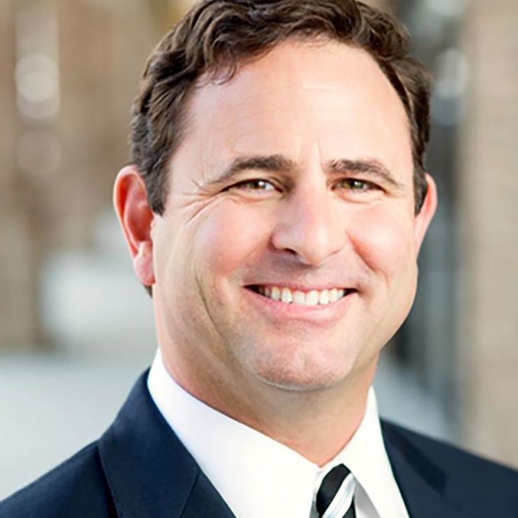 A man in a suit and tie is smiling for the camera.