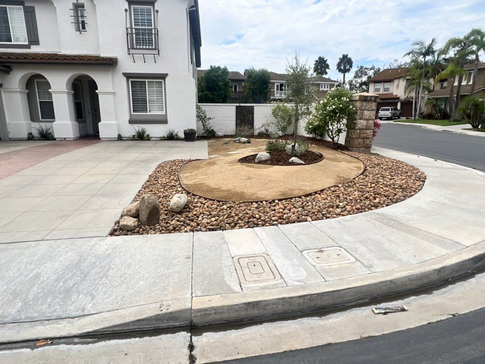 A corner of a street with a house in the background