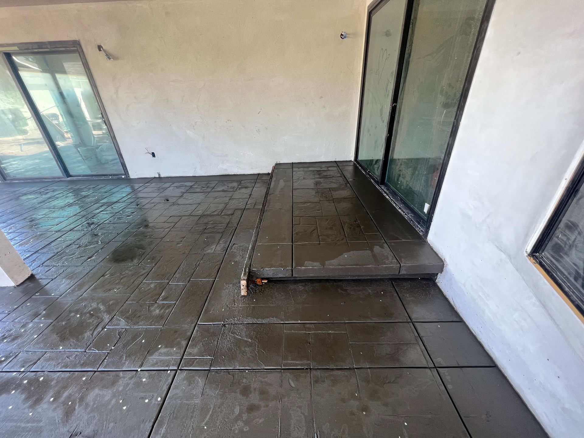 A room with a tiled floor and sliding glass doors.