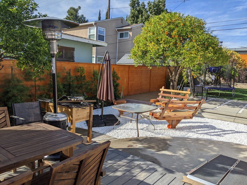 A backyard with a table and chairs and a patio heater.