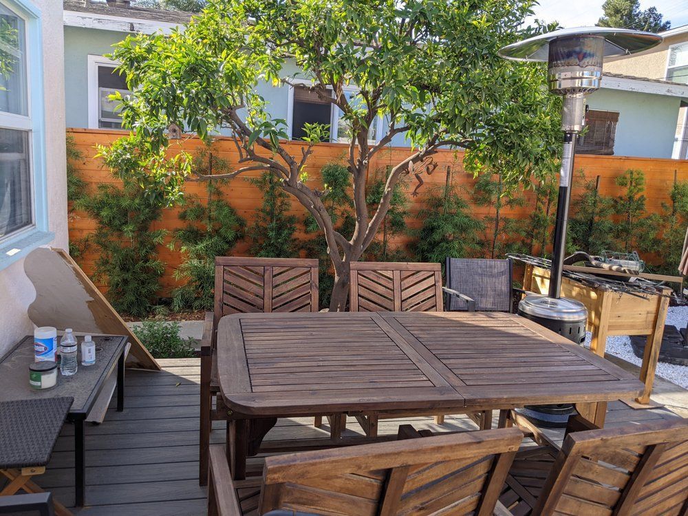 A wooden table and chairs are sitting on a wooden deck.
