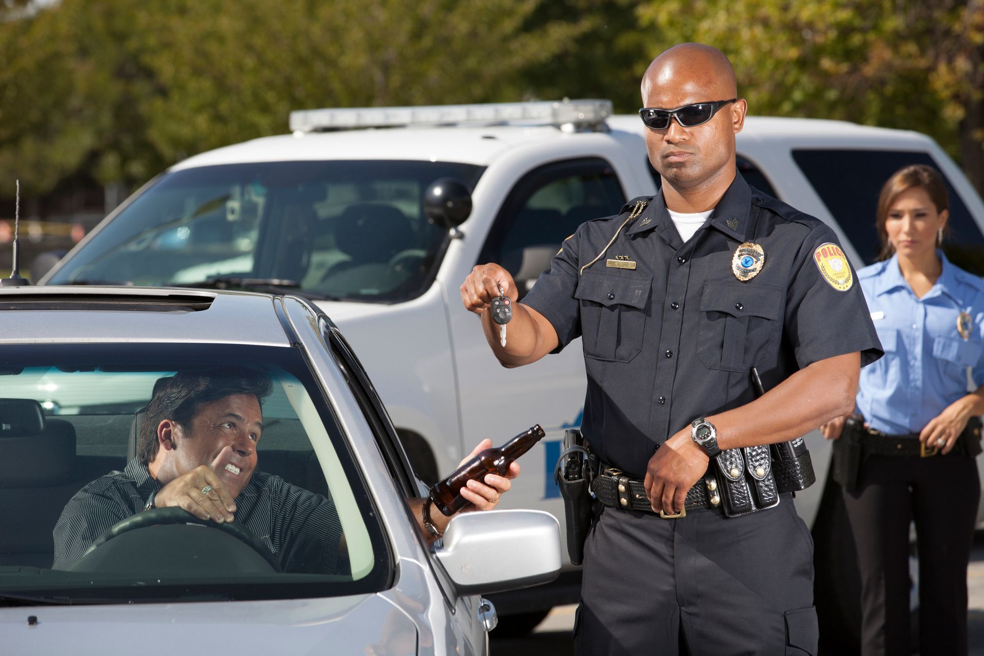 A police officer is talking to a man in a car.