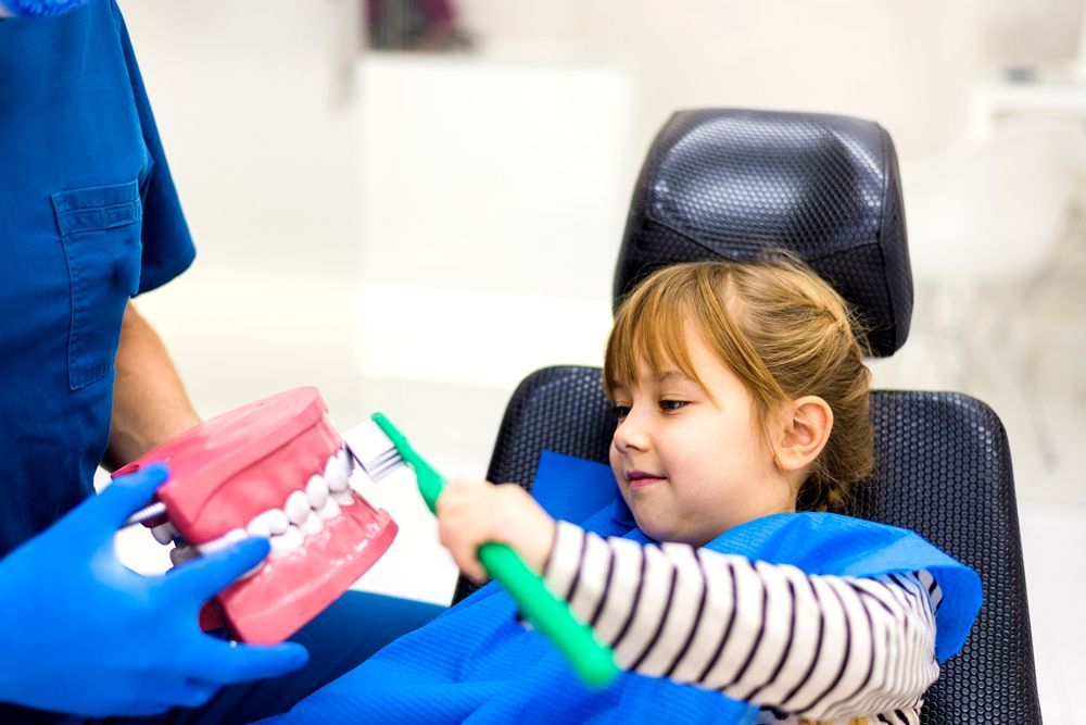 Little Girl Holding Big Toothbrush — Novi, MI — Olde Orchard Pediatric