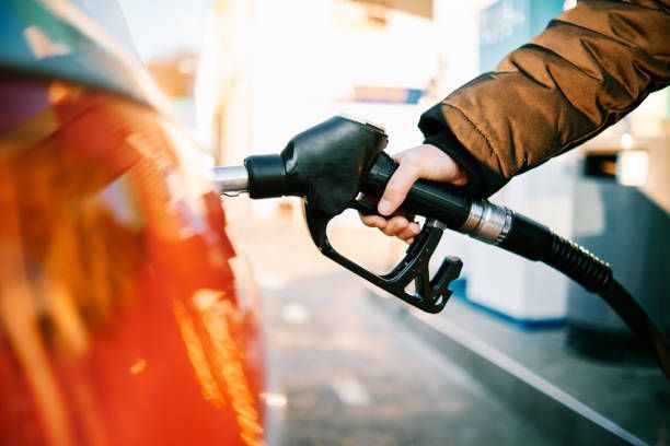 Close-up of a hand in a gas pump fueling a car.
