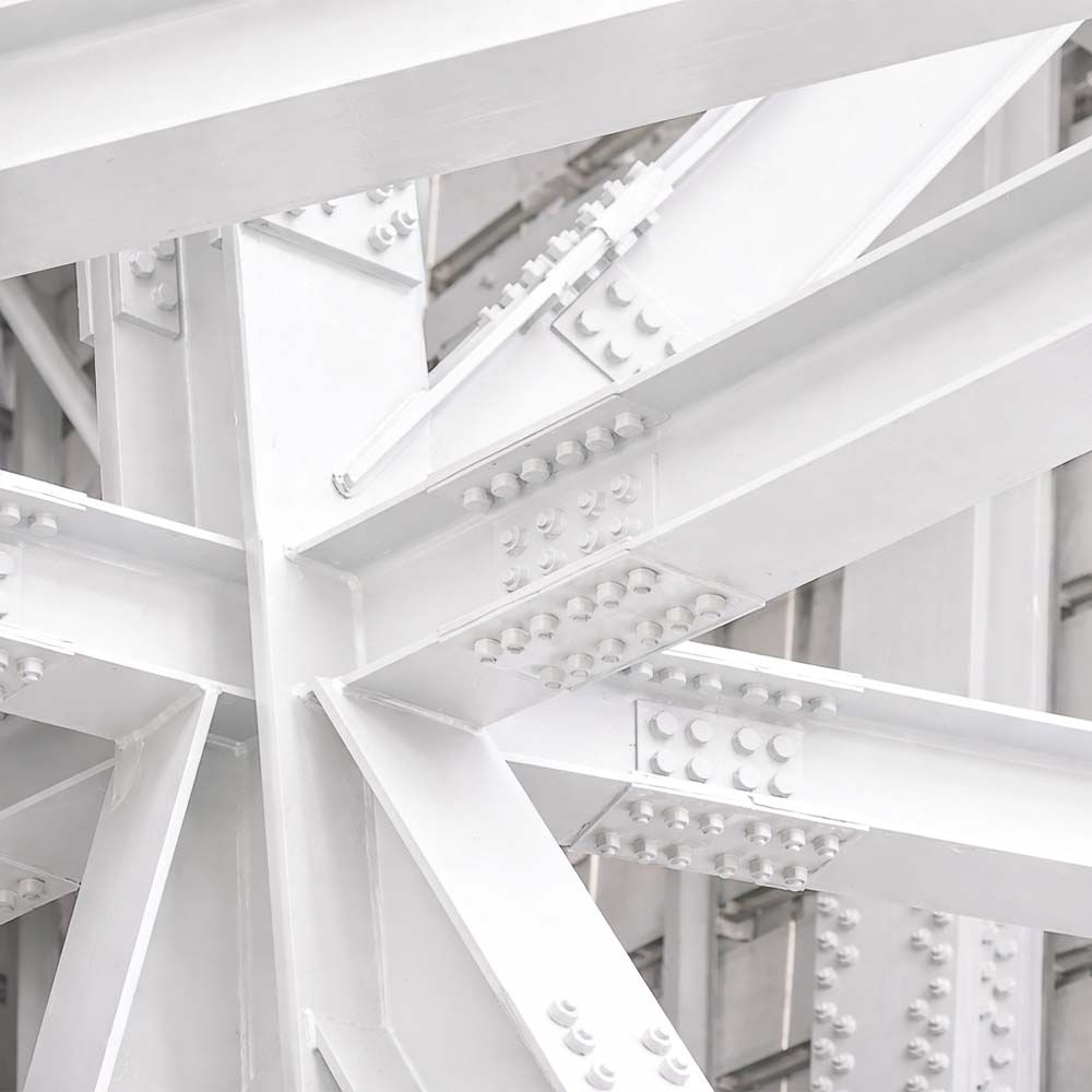 White steel structural beams, bolted together, forming a strong framework.