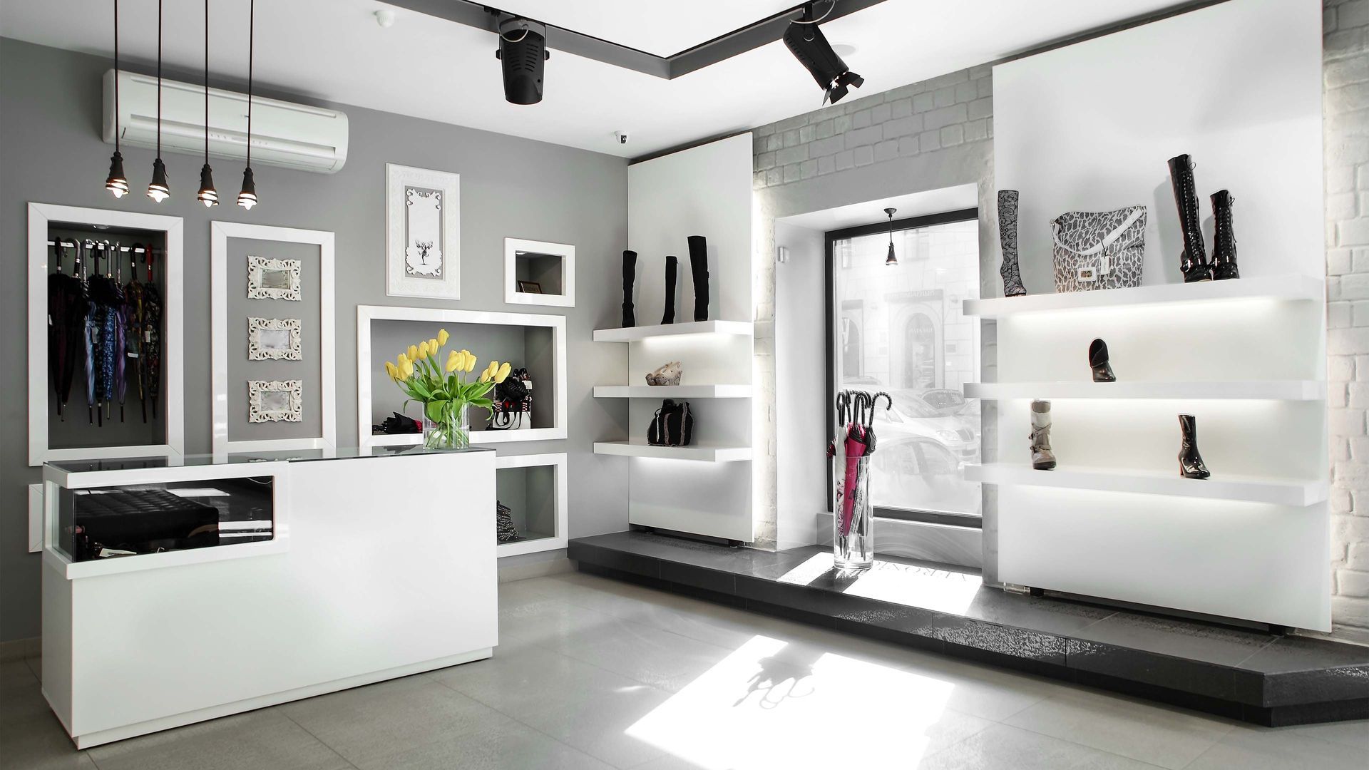 Modern shoe store interior with white display shelves, gray walls, and bright lighting.