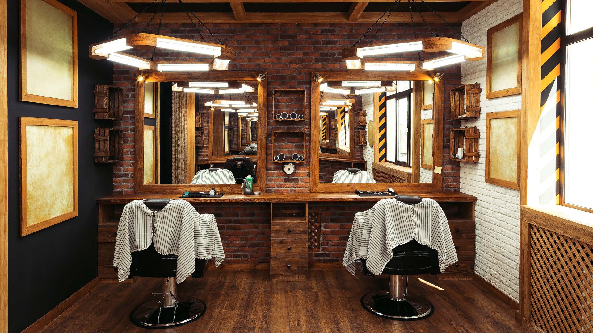 Barbershop interior with two stations, mirrors, chairs, and brick accents.