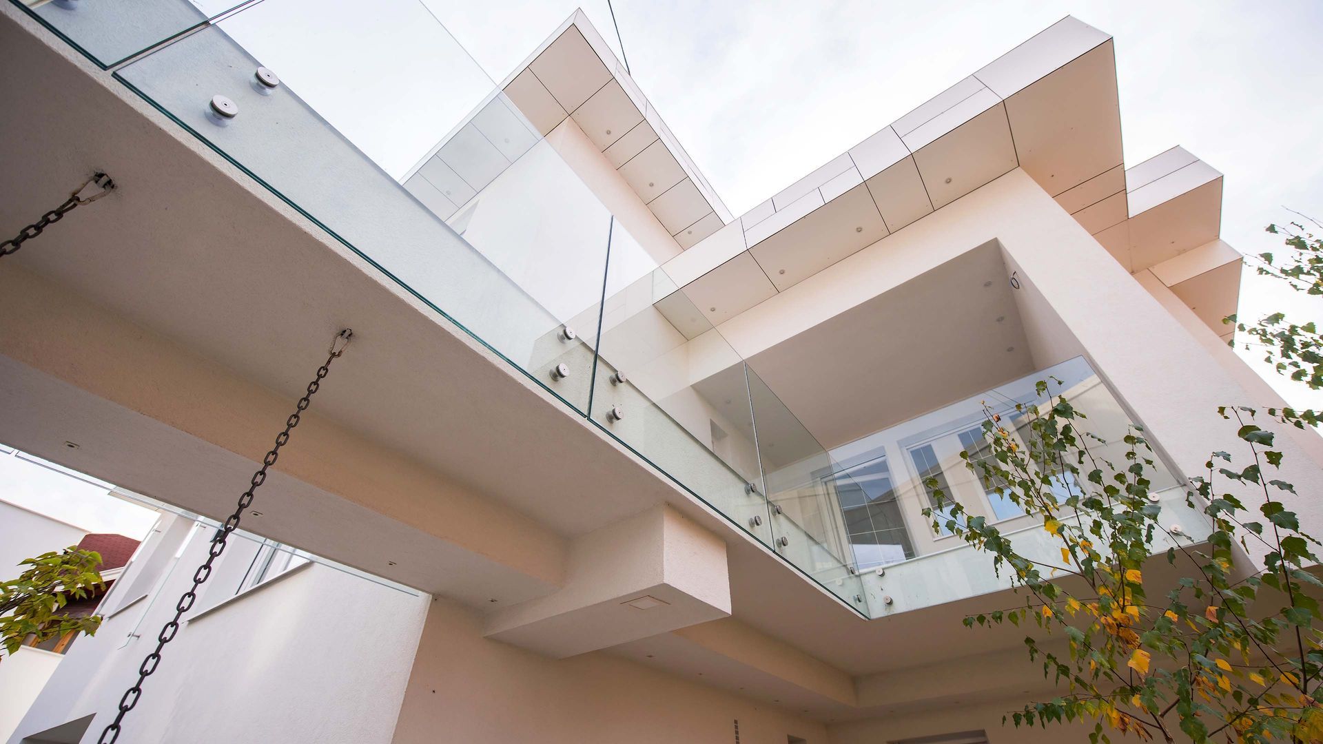 Modern white architectural structure with layered balconies and glass railing