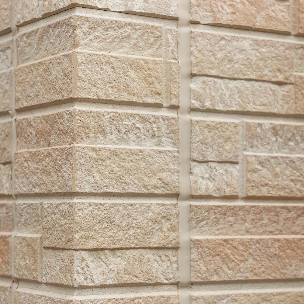 Close-up of textured stone masonry wall corner with mortar joints