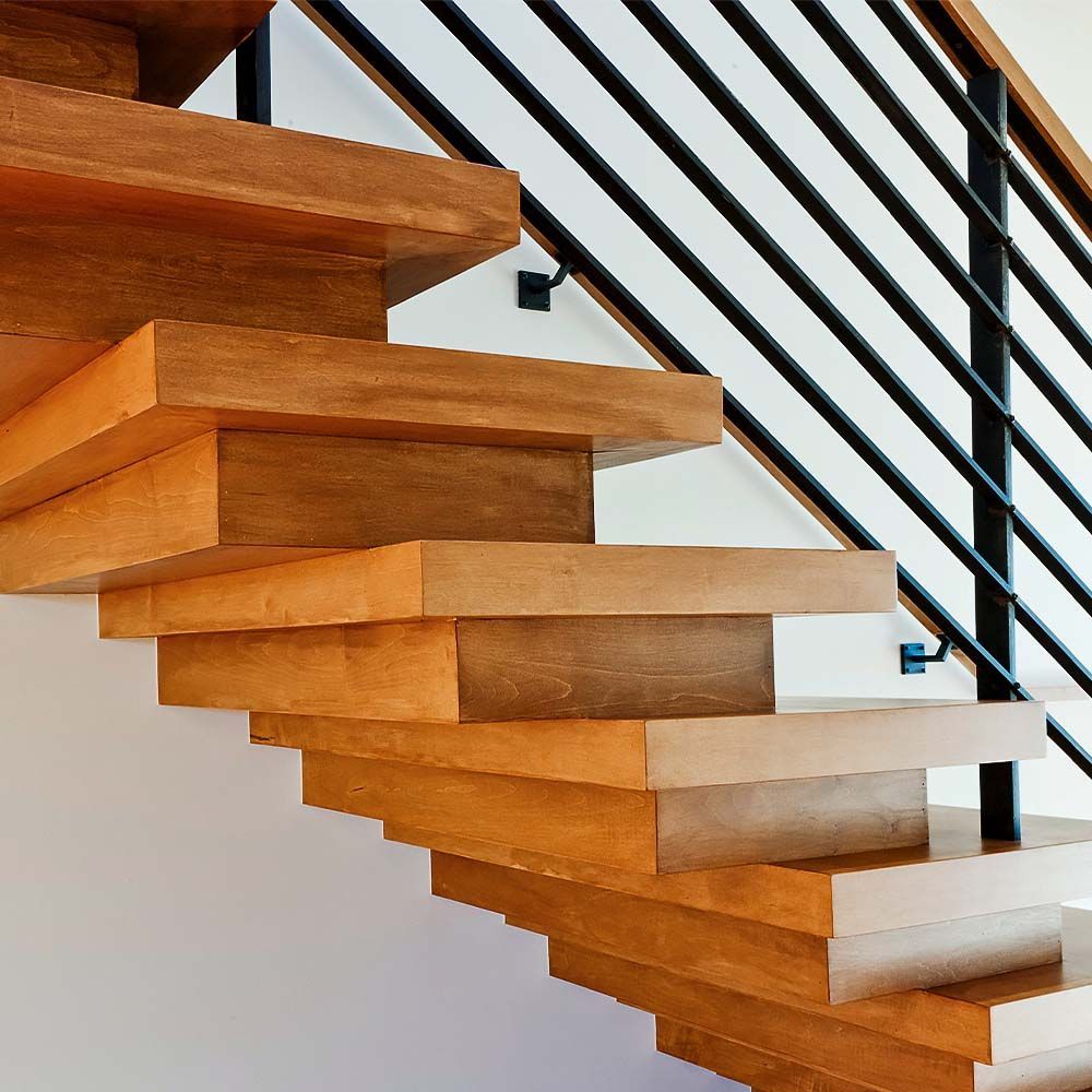 Wooden floating staircase with black metal railing.