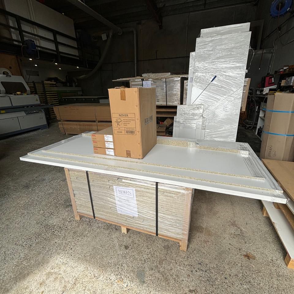 A Pallet of White Panels in a Warehouse Setting — Maken Kitchens & Cabinets in Chinderah, NSW