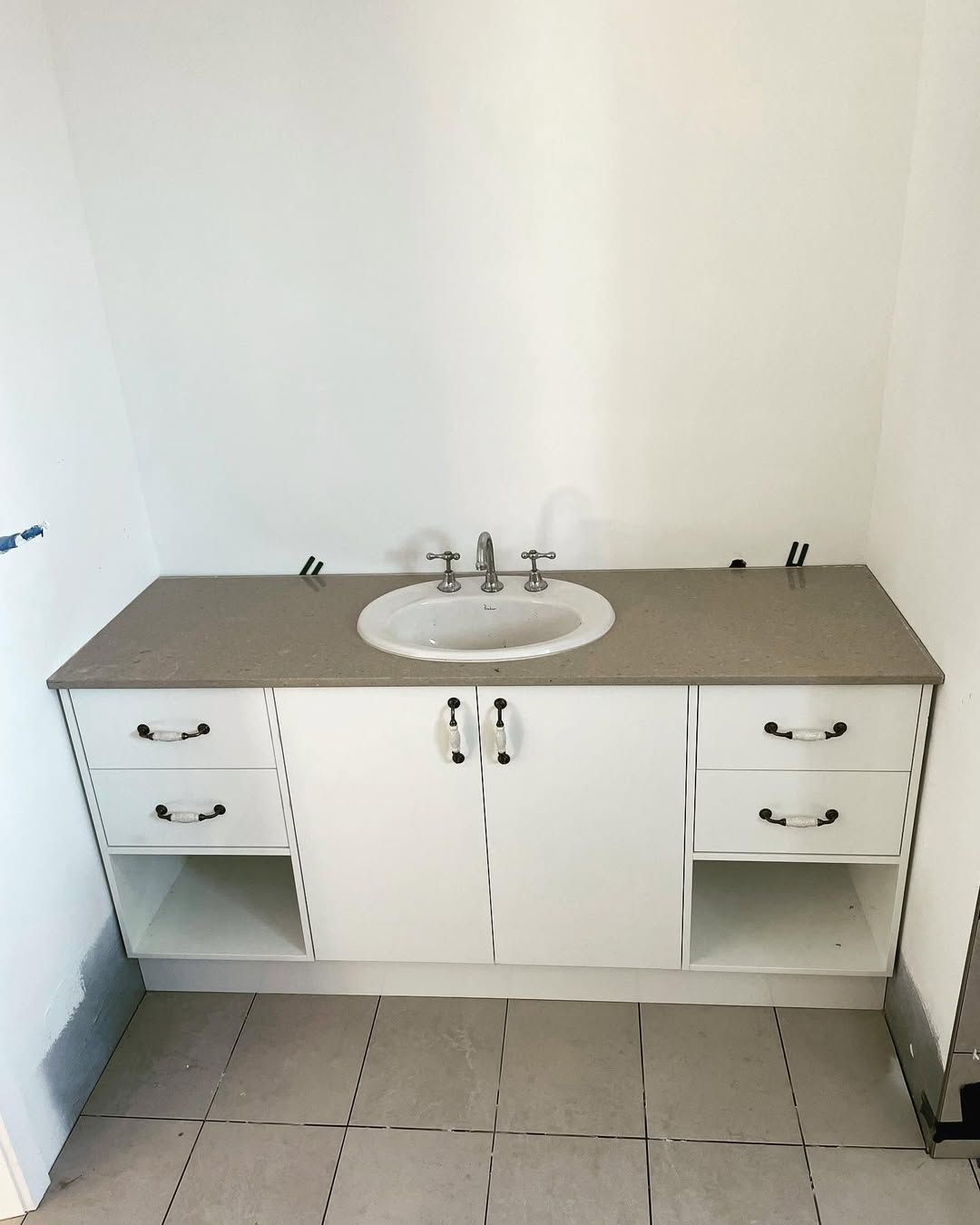 White bathroom vanity with drawers and cabinets, gray countertop, and round sink. — Maken Kitchens & Cabinets in Lismore, NSW