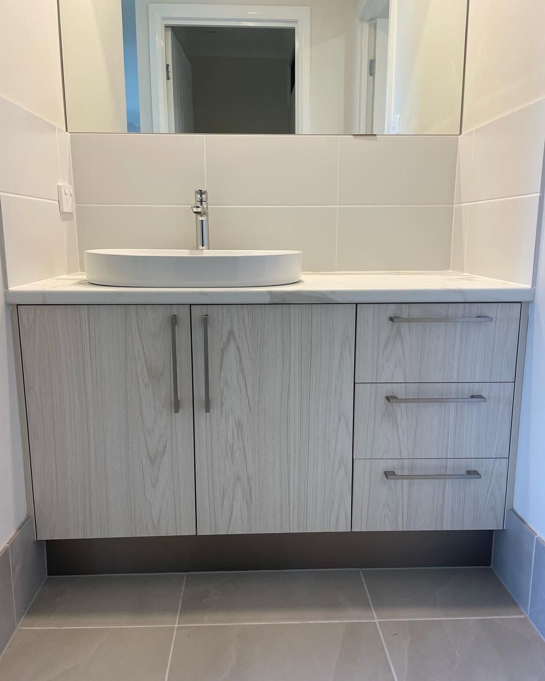 Modern Kitchen With Grey and White Cabinets and a Grey Island With a Sink — Maken Kitchens & Cabinets in Byron Bay, NSW