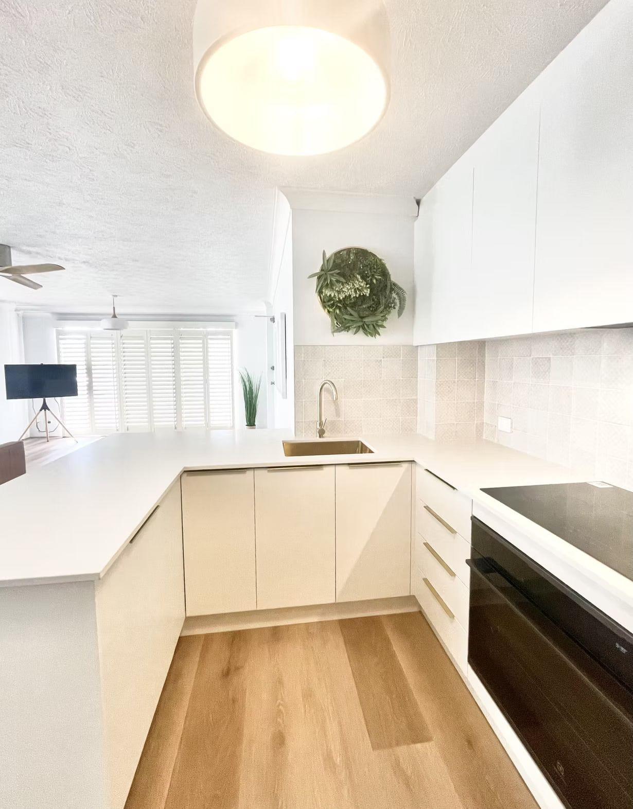 A White Kitchen With an Open Dishwasher and Cabinetry and a White Countertop — Maken Kitchens & Cabinets in Chinderah, NSW