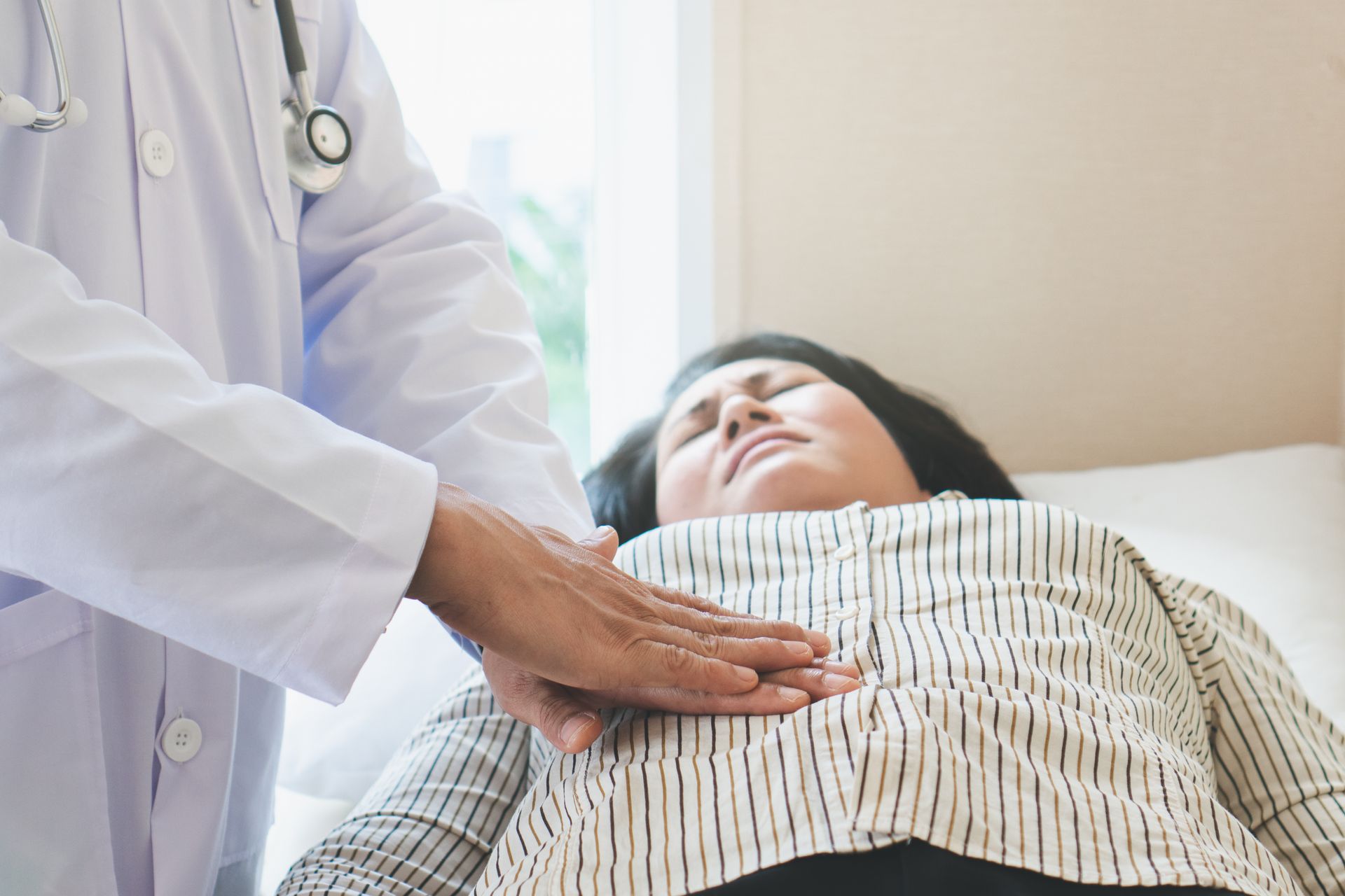 A doctor is examining the stomach of a woman. A doctor is examining the stomach of a woman.