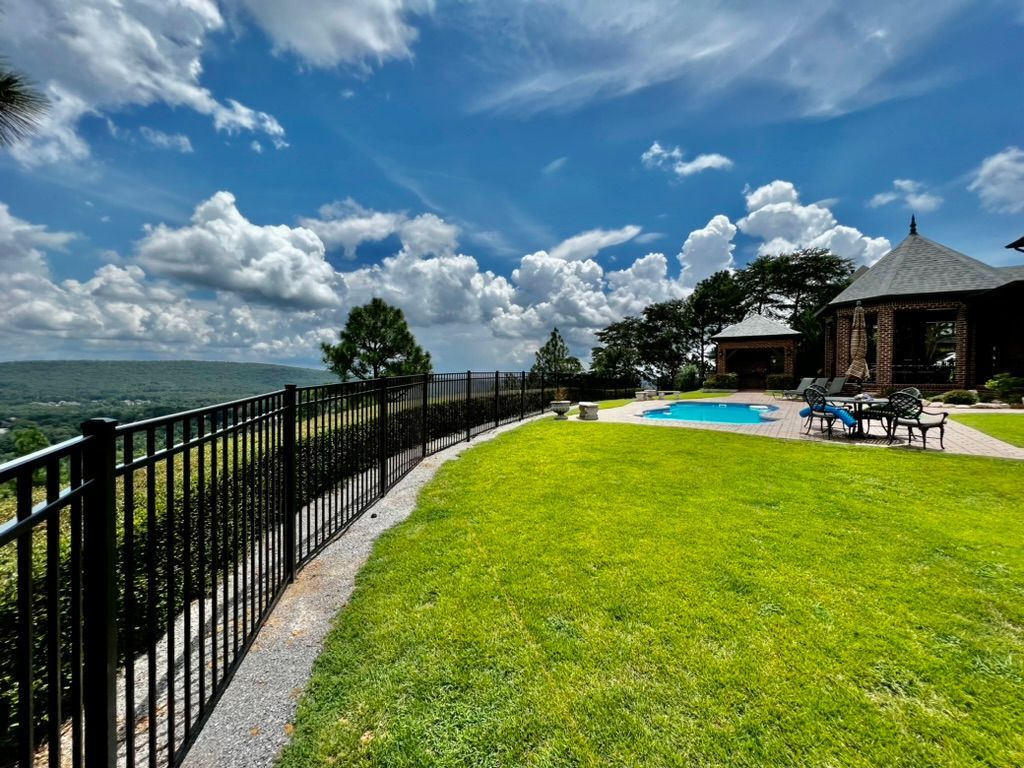 There is a large swimming pool in the backyard of a house.