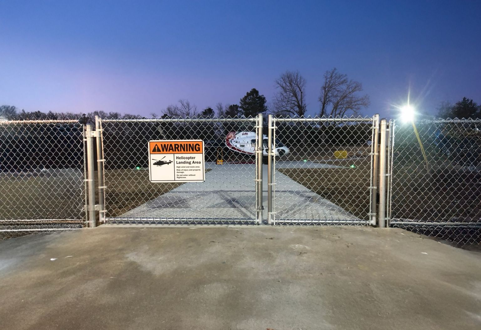 A chain link fence with a warning sign on it