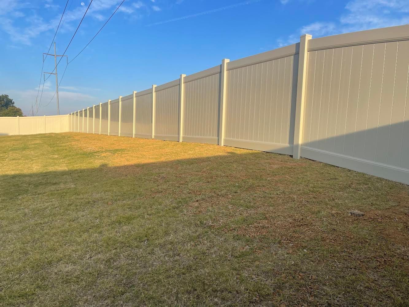 A white fence is sitting in the middle of a grassy field.