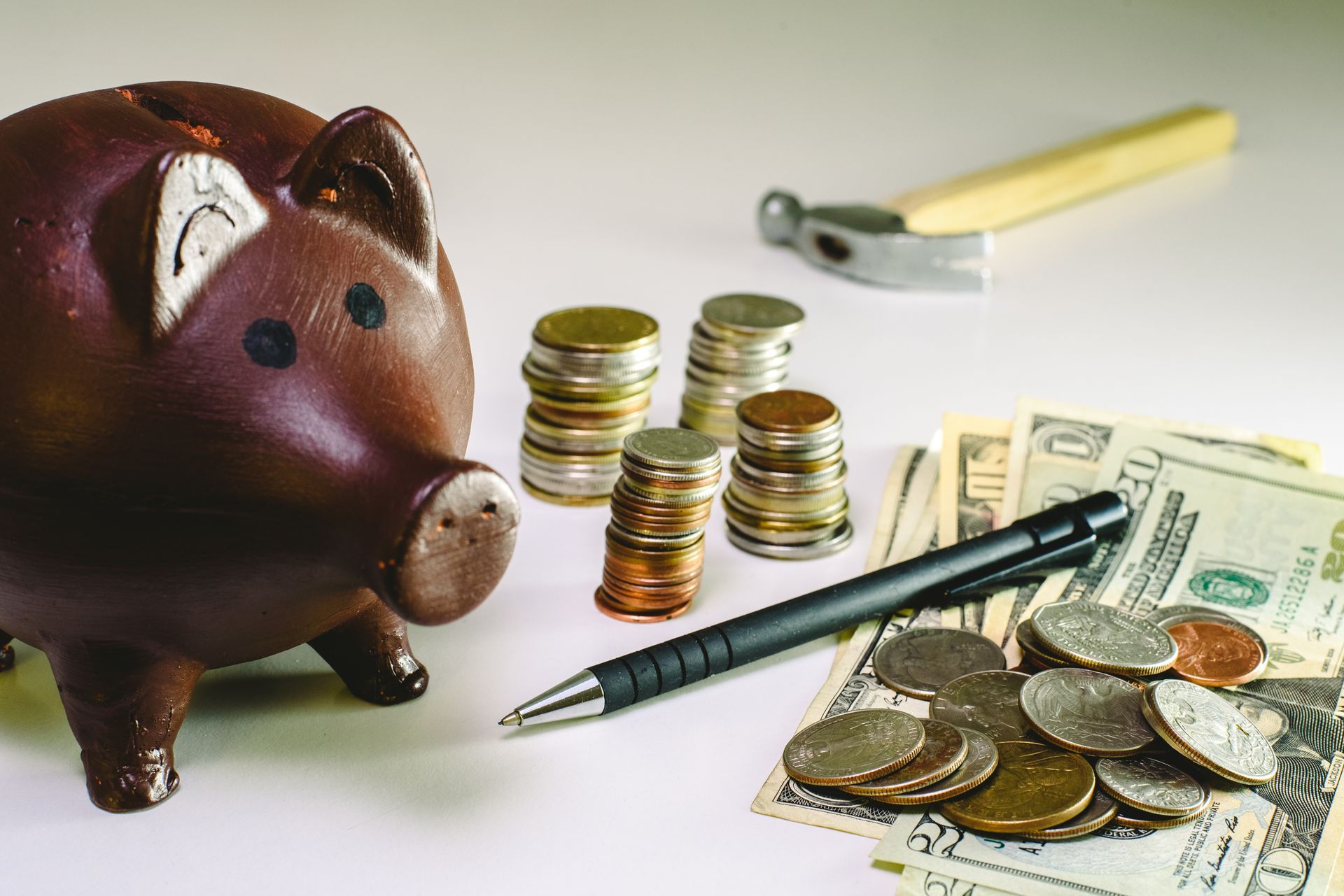 A piggy bank is surrounded by stacks of coins and money.
