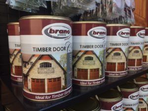 Tins of Brano's timber door care treatment for wood