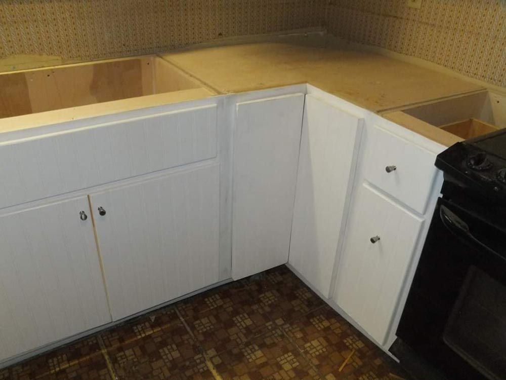 A kitchen with white cabinets and a black stove