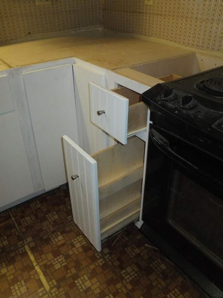 A kitchen with a stove and a drawer open