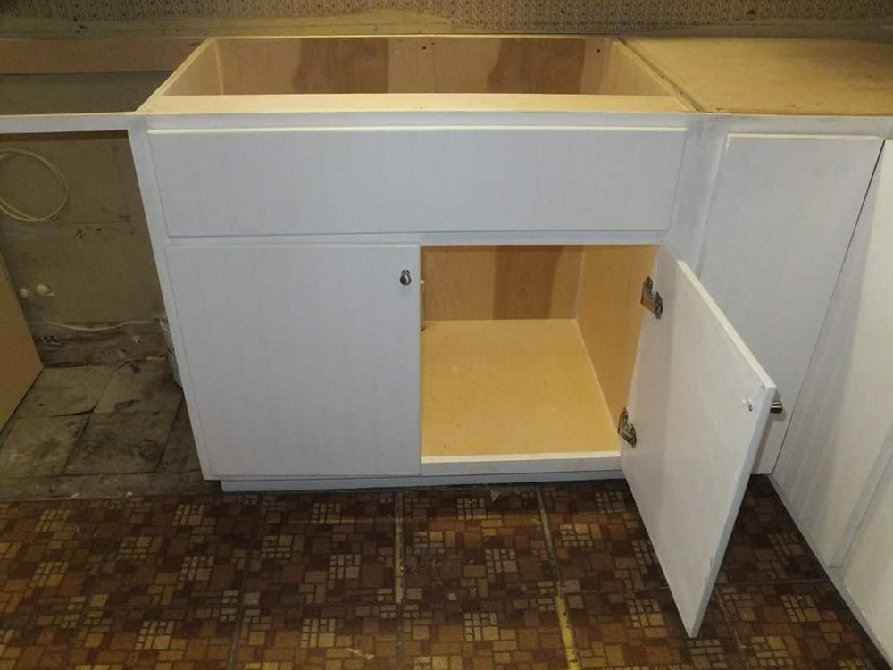 A white cabinet with the door open in a kitchen