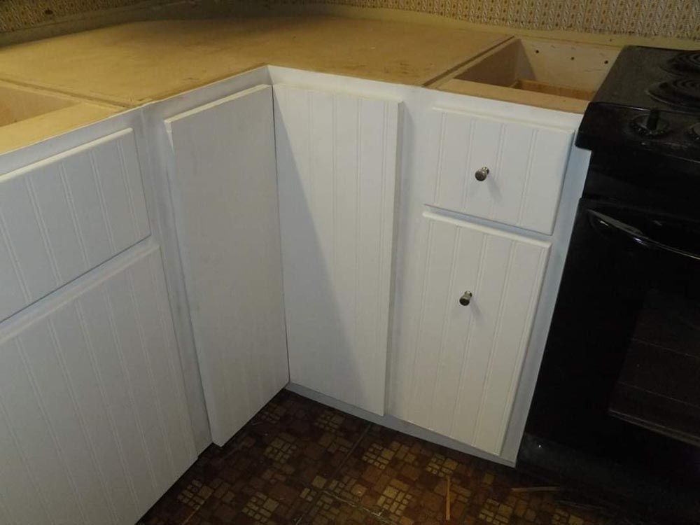 A kitchen with white cabinets and a black stove.