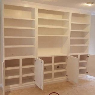 A large white bookshelf with the doors open in a living room.