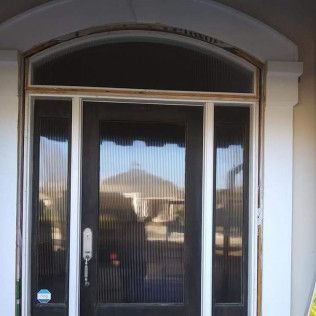 A front door with a sliding glass door and a sliding glass window.