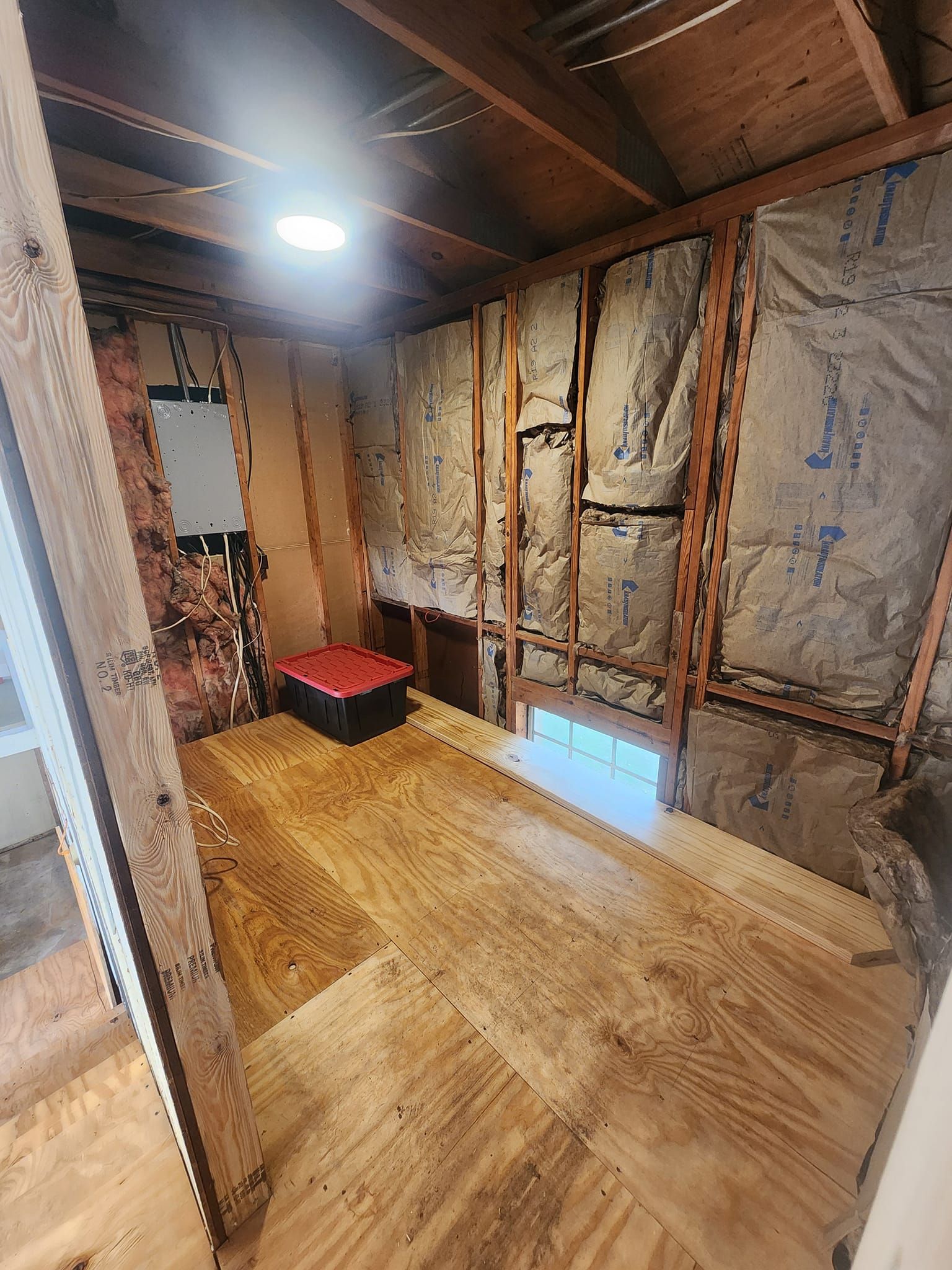 A room with a wooden floor and insulation on the walls.