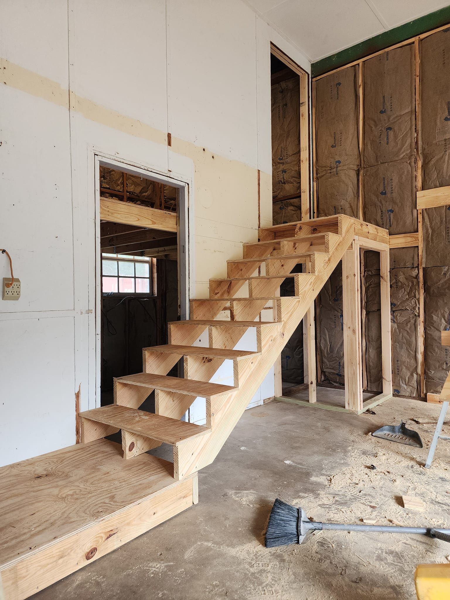 A wooden staircase is being built in a room.