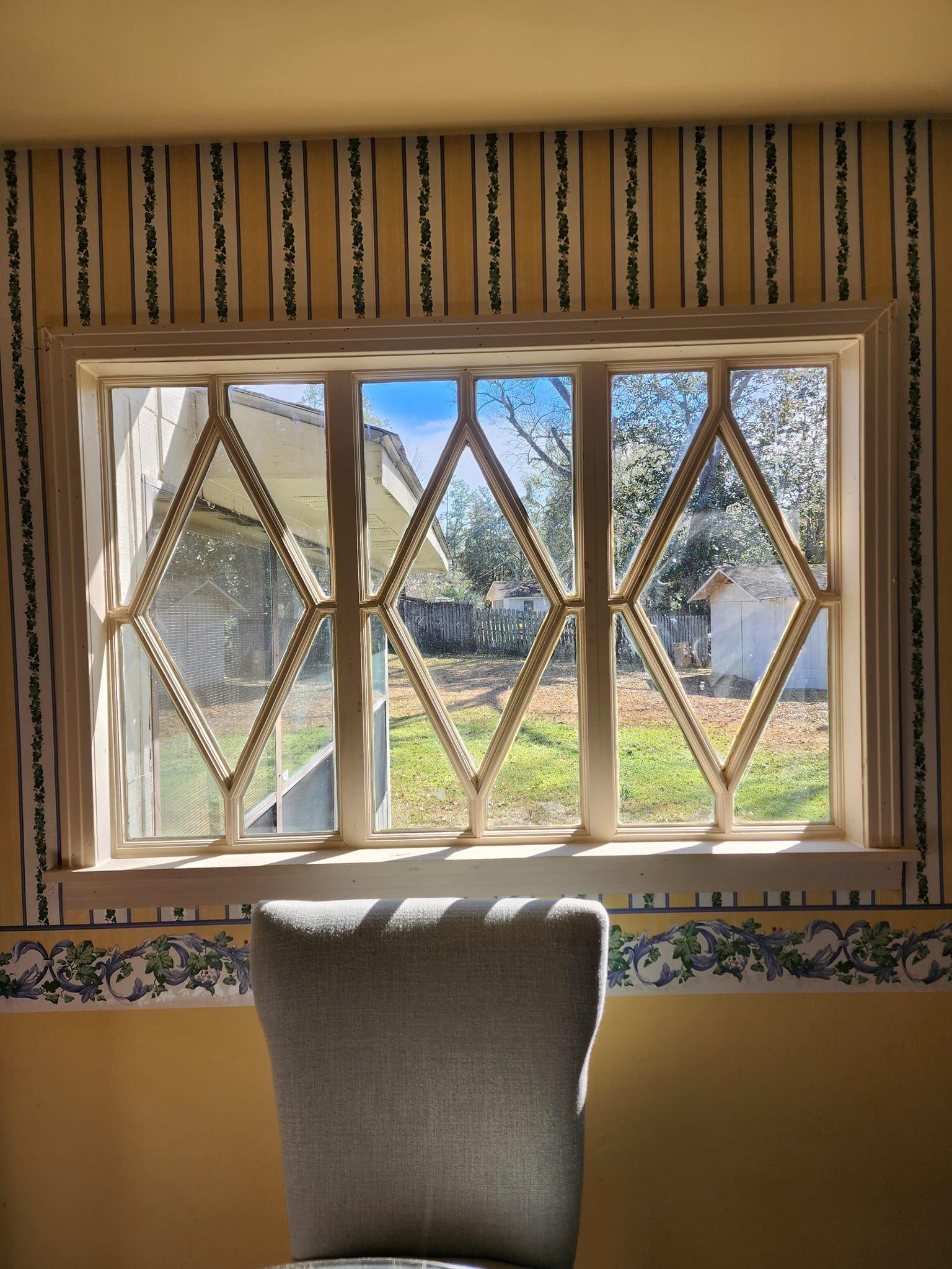 A chair in front of a window with a view of a field