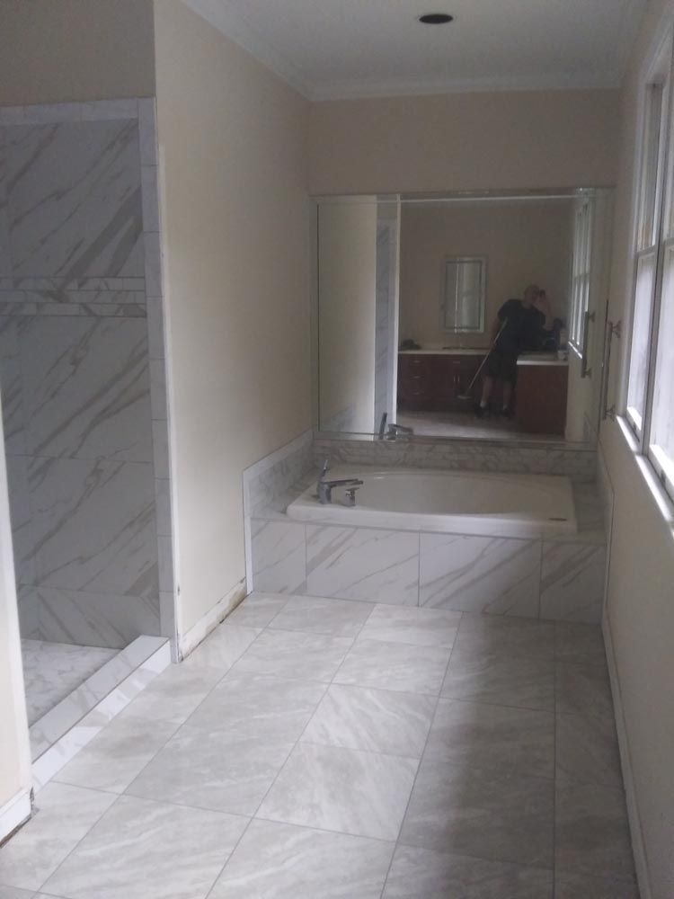 A bathroom with a bathtub and a walk in shower.