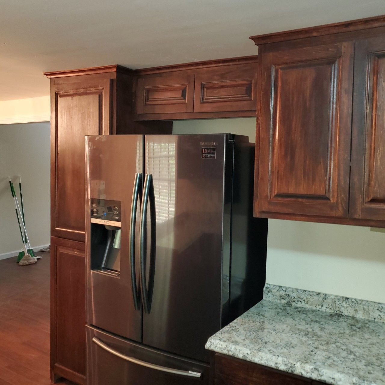 A kitchen with a stainless steel refrigerator and wooden cabinets