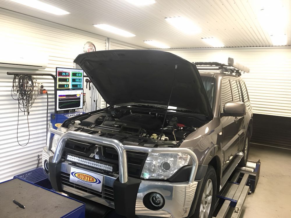 A Car With The Hood Up Is Sitting On A Ramp In A Garage — Hunter Automotive In Bungalow, QLD