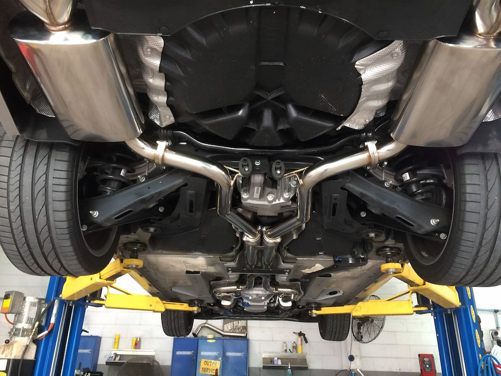 A Car Is Sitting On A Lift In A Garage — Hunter Automotive In Bungalow, QLD