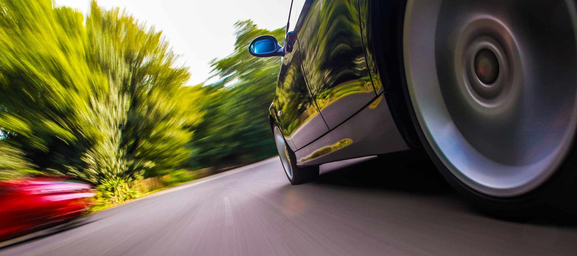 A Car Is Driving Down A Road With Trees In The Background — Hunter Automotive In Tablelands, QLD