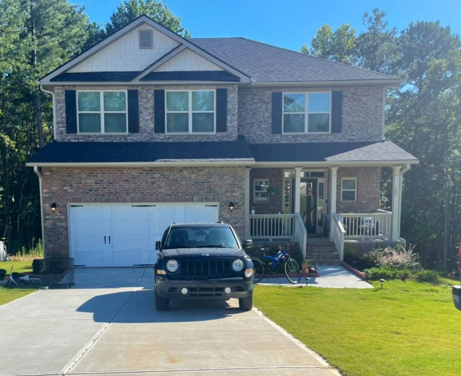 A jeep is parked in front of a large brick house