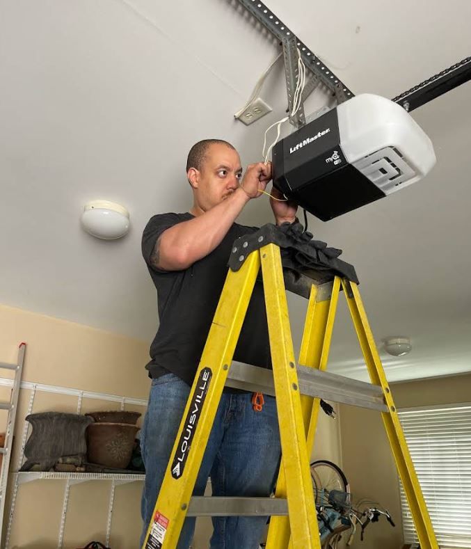 A man standing on a yellow ladder working on a garage door opener