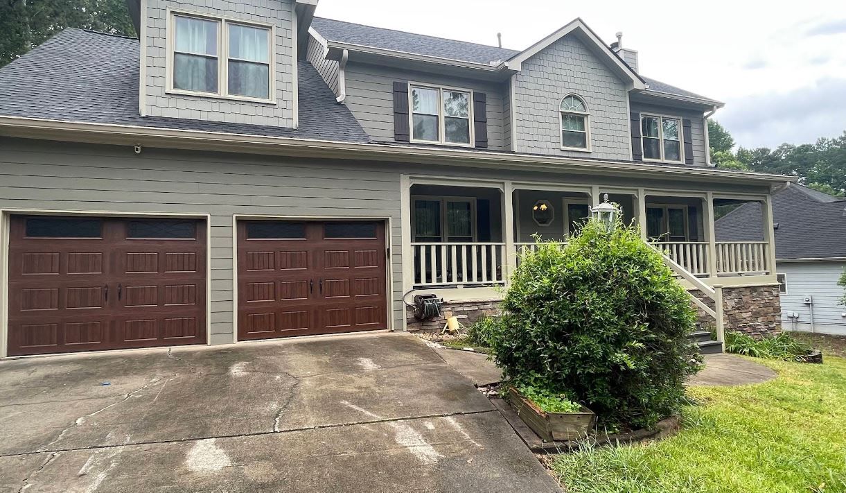 A large house with two garage doors and a porch.