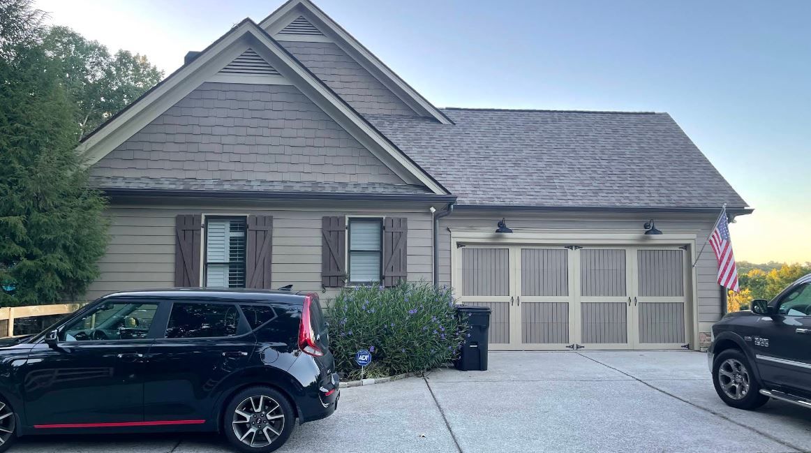 A black suv is parked in front of a house.