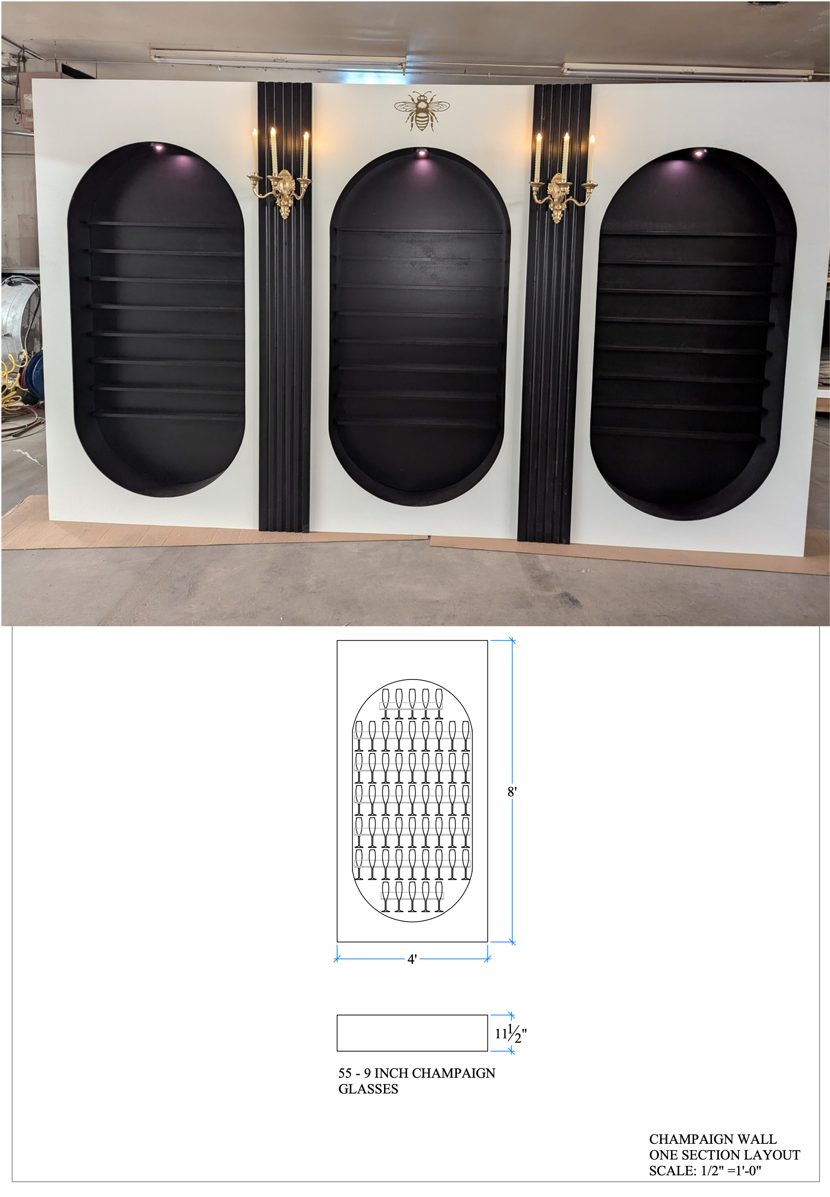 Display with three black arched shelves, gold sconces, and architectural detailing.