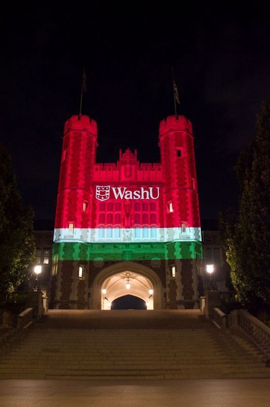 Night view of WashU's Brookings Hall lit in red, green, and white, resembling the Hungarian flag.